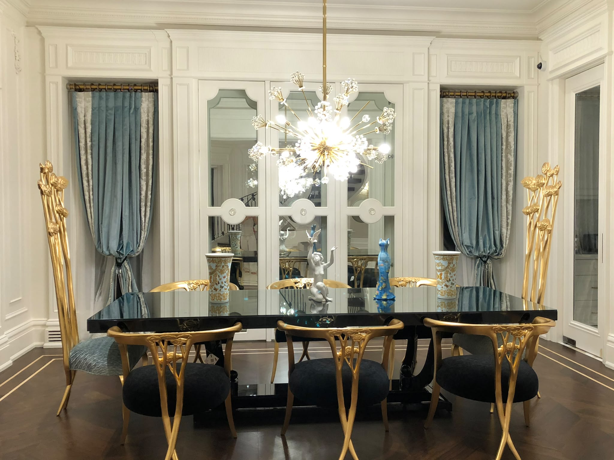 Custom blue drapery with decorative side panels in an elegant dining room